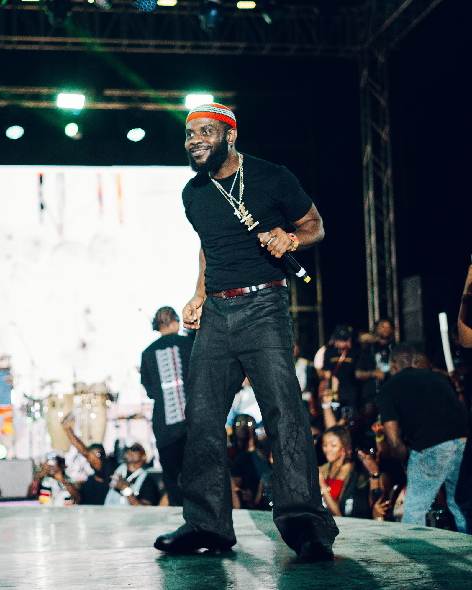 A performer pointing to the crowd under red stage lights